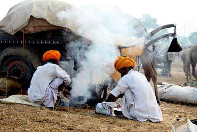 Rear view of people working at temple