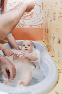 Mother giving bath to baby boy 