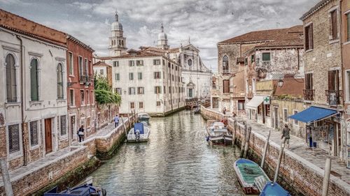 Boats in canal along buildings