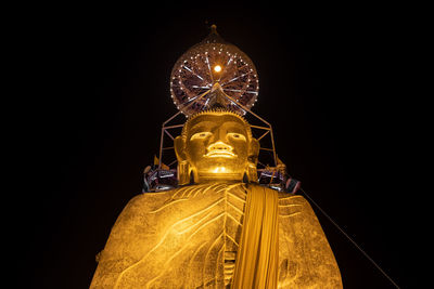 Low angle view of illuminated statue against sky at night