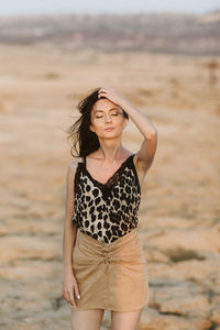 Portrait of a beautiful young woman standing on beach