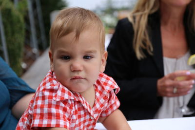 Close-up of cute baby boy looking away while sitting on table