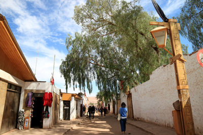 People walking on footpath amidst buildings in city