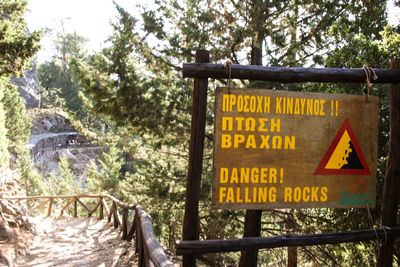 Close-up of warning sign on wooden gate