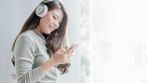 Side view of young woman using mobile phone