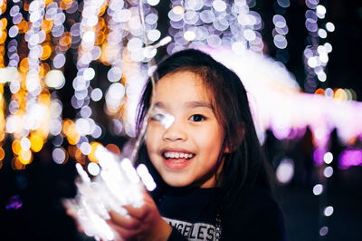 Portrait of smiling woman with illuminated lights