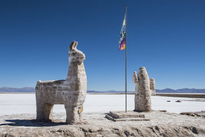 Traditional windmill on rock against clear blue sky