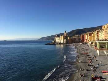 View of sea and buildings against clear blue sky