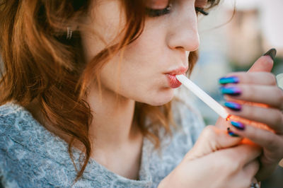 Close-up of beautiful woman smoking cigarette