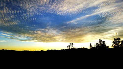 Silhouette of landscape against cloudy sky