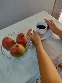 High angle view of hand holding drink on table