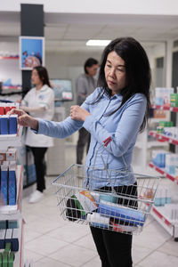 Portrait of young woman holding shopping cart