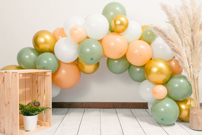 Multi colored balloons on table against wall