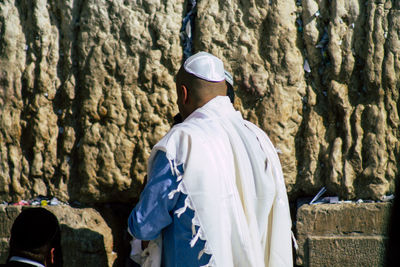 Rear view of man standing at temple