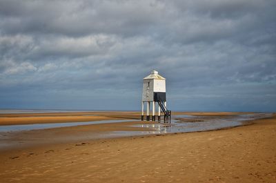 Lifeguard hut on beach against sky