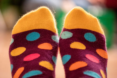 Low section of person wearing colorful spotted socks