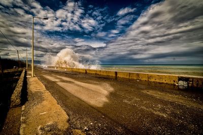 Road by sea against sky