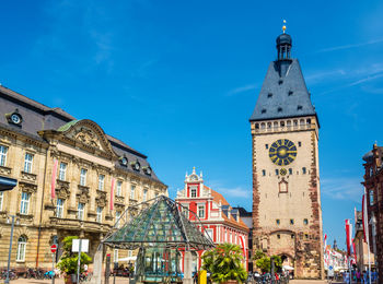 Low angle view of buildings in city against blue sky