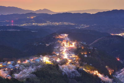 Aerial view of illuminated city against sky at night