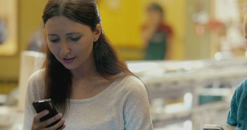 Portrait of young woman using mobile phone outdoors