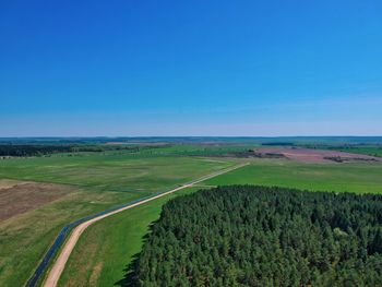 Scenic view of agricultural field against blue sky