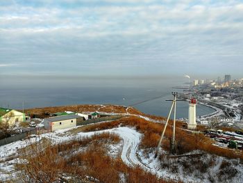 High angle view of buildings by sea against sky