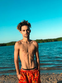 Portrait of shirtless man standing at beach