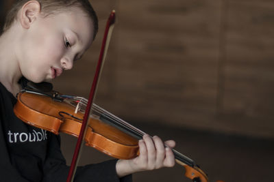 Close-up of boy playing violin