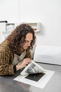 Female artist inspecting the results after operating a manual vi