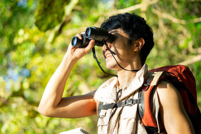 Man photographing with camera while standing outdoors