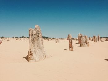 Panoramic view of desert against clear blue sky