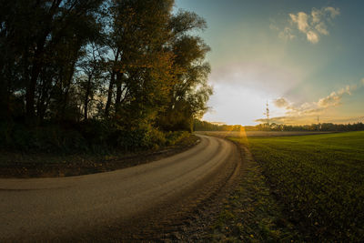 Road amidst trees against sky