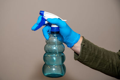 Close-up of hand holding blue over white background