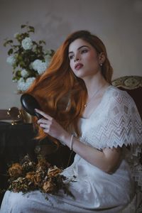 Portrait of young woman sitting on sofa at home