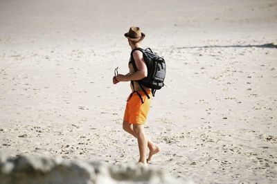 Rear view of woman walking on beach