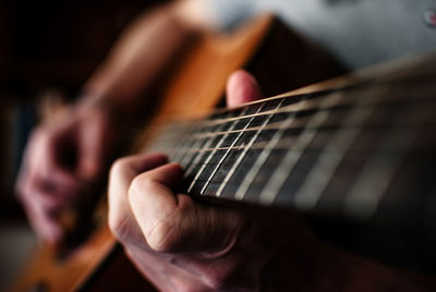 Cropped image of musician playing acoustic guitar