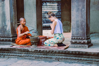 People sitting on wall by building