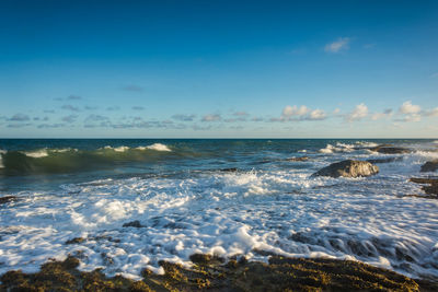 Scenic view of sea against blue sky