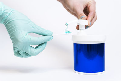 Midsection of man holding glass against white background