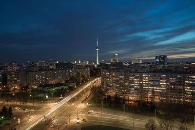 High angle view of illuminated street amidst buildings in city at night