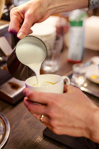 Cropped image of woman making coffee in kitchen