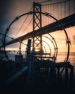 Silhouette bridge against sky during sunset