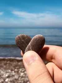 Midsection of person holding sea against sky