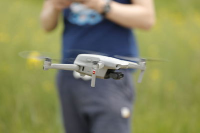 Close-up of man holding camera while standing on field