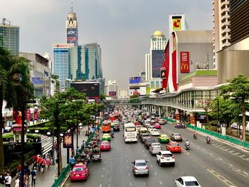 Traffic on city street amidst buildings against sky