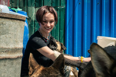 Dog at the shelter.  lonely dogs in cage with cheerful woman volunteer