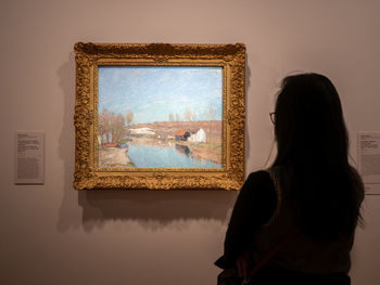 Rear view of woman standing against wall