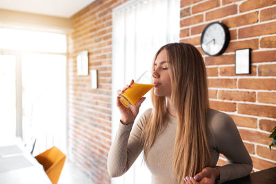 Portrait of young woman drinking glass