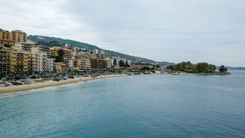 Panoramic view of sea and buildings against sky