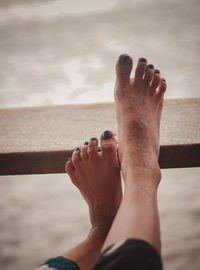 Low section of woman relaxing in sea against sky